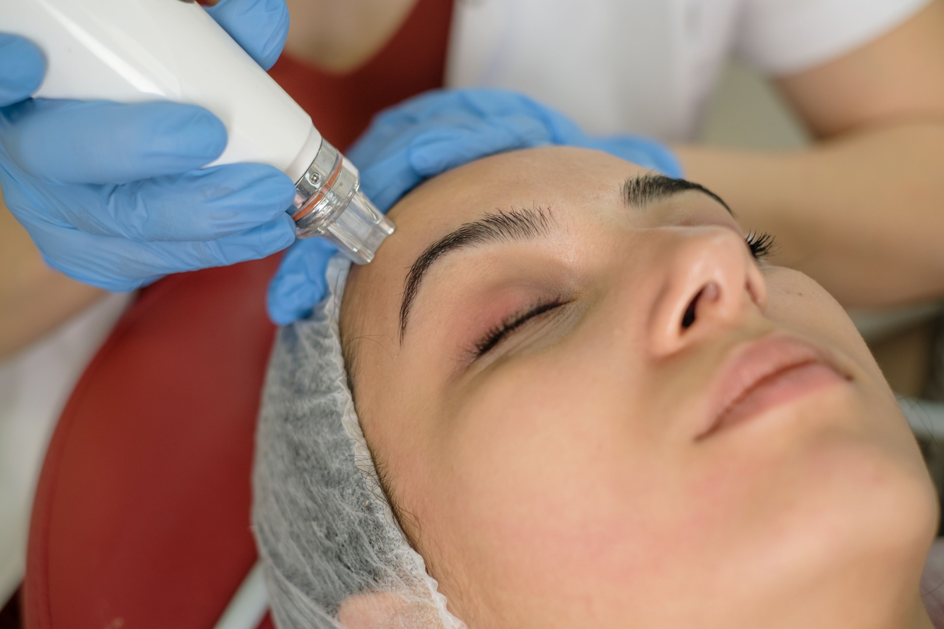 Cosmetólogo haciendo tratamiento de mesoterapia en la cara de una mujer